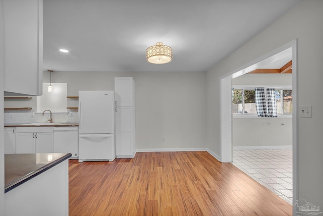 kitchen featuring open shelves, white appliances, a sink, and white cabinetry