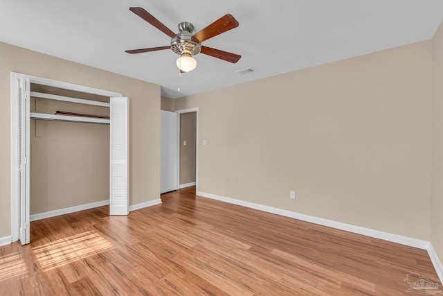 unfurnished bedroom with a closet, visible vents, a ceiling fan, light wood-type flooring, and baseboards