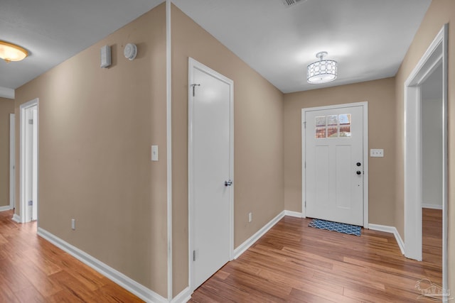 entryway featuring baseboards and light wood finished floors