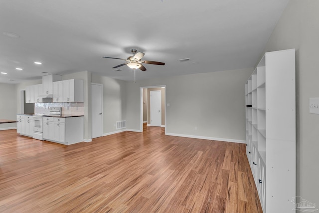 unfurnished living room with a ceiling fan, baseboards, visible vents, and light wood finished floors