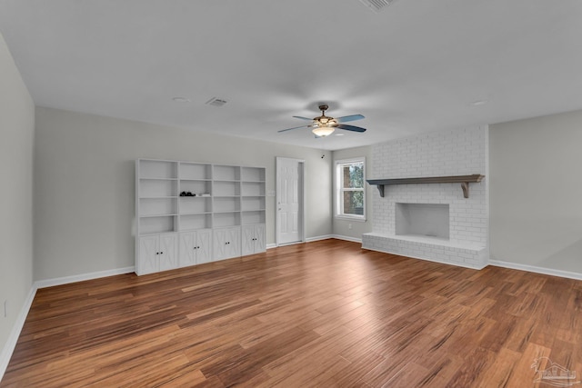 unfurnished living room with a ceiling fan, a fireplace, baseboards, and wood finished floors