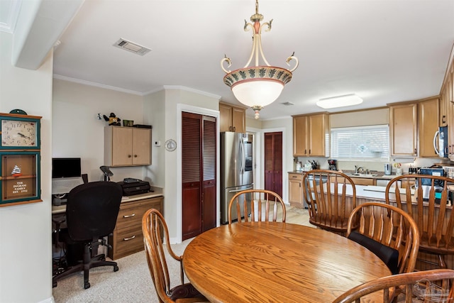 carpeted dining space featuring sink and crown molding