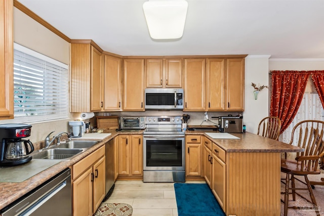 kitchen with sink, stainless steel appliances, light hardwood / wood-style flooring, crown molding, and a kitchen bar