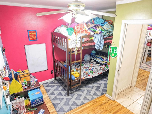 bedroom featuring wood finished floors, baseboards, and ornamental molding