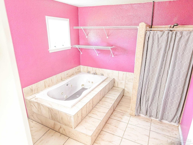 bathroom featuring marble finish floor, a jetted tub, a shower with curtain, and a textured wall