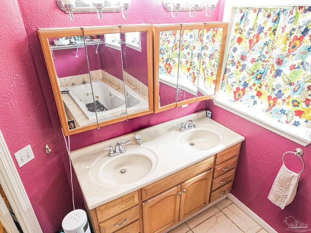 bathroom with double vanity, a textured wall, and a sink