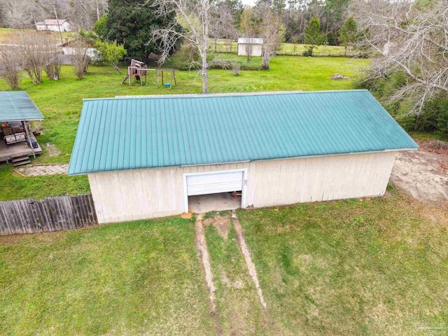 view of pole building with a yard, driveway, and fence