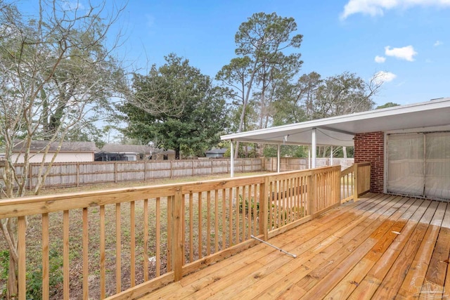 wooden terrace with a fenced backyard