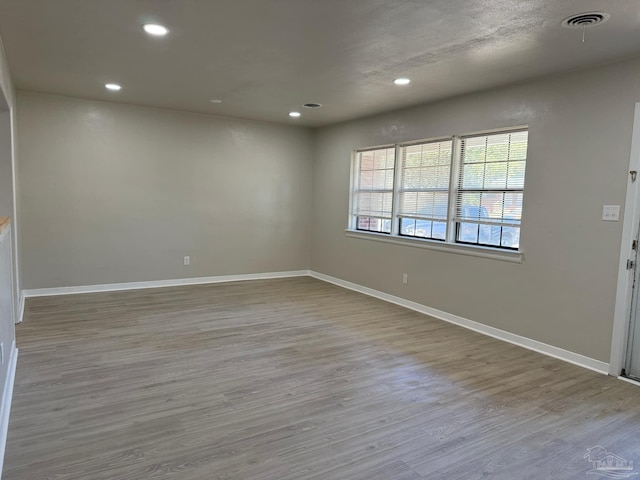 unfurnished room featuring light wood-style floors, visible vents, and recessed lighting