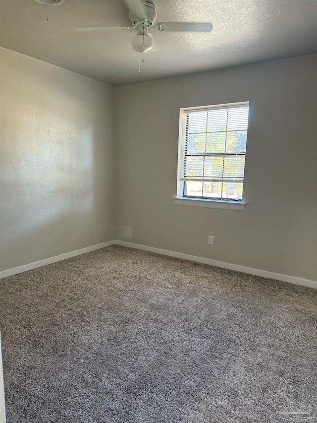 empty room with ceiling fan, carpet floors, and baseboards