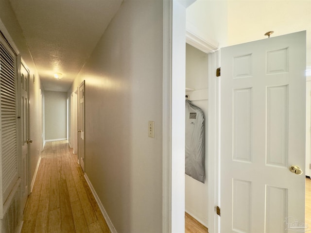 hallway with wood finished floors and baseboards