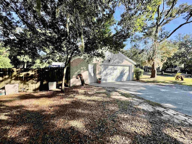 garage with driveway and fence