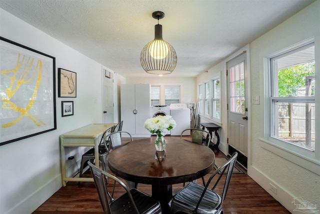 dining area with dark hardwood / wood-style flooring and separate washer and dryer