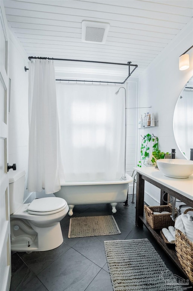 full bathroom featuring toilet, vanity, tile patterned floors, and shower / bath combo with shower curtain