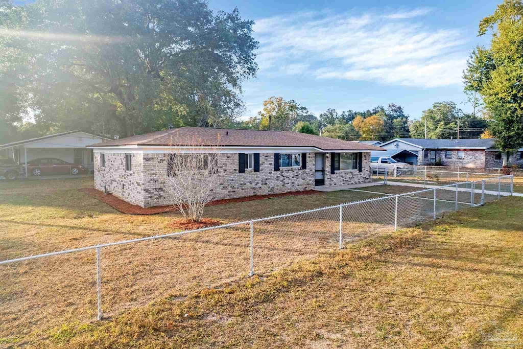 ranch-style house featuring a carport and a front lawn