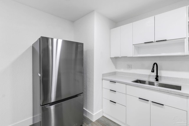 kitchen with stainless steel fridge, dark hardwood / wood-style floors, white cabinetry, and sink