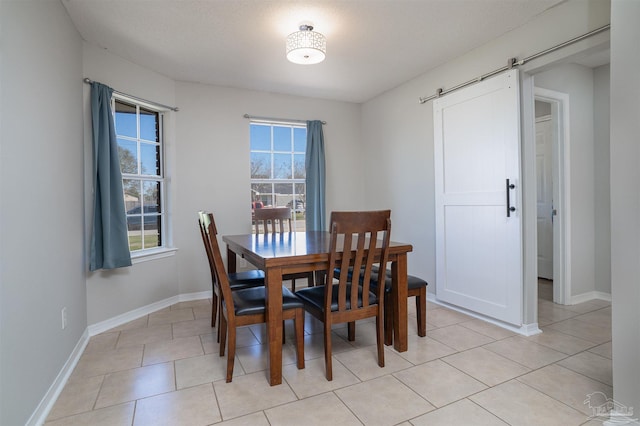4005 Shorewood Dr, Pensacola, FL 32507 - dining area with baseboards, a barn door, and light tile patterned floors