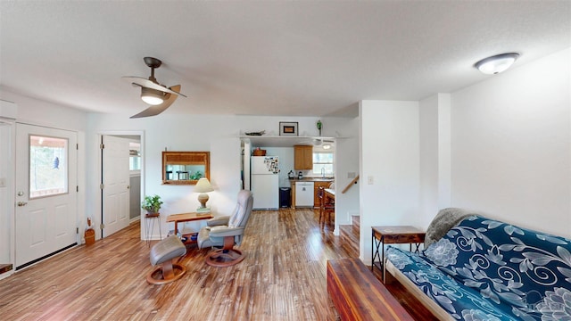 foyer entrance featuring ceiling fan, stairs, baseboards, and wood finished floors