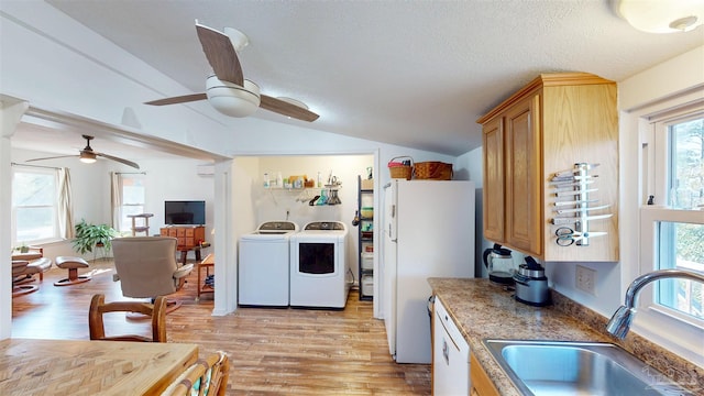 kitchen with light wood-style floors, vaulted ceiling, a sink, washer and dryer, and white appliances