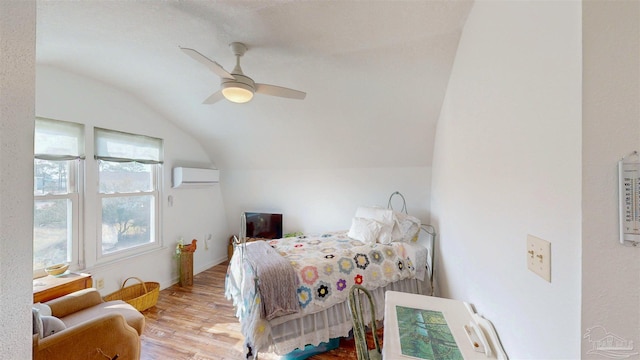 bedroom featuring a wall unit AC, ceiling fan, vaulted ceiling, and wood finished floors