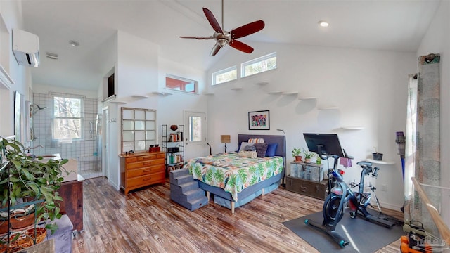 bedroom featuring high vaulted ceiling, wood finished floors, multiple windows, and a wall mounted AC