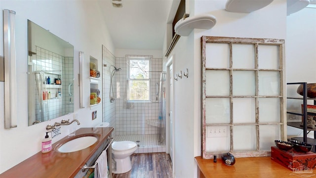 bathroom with vanity, wood finished floors, a shower stall, and toilet