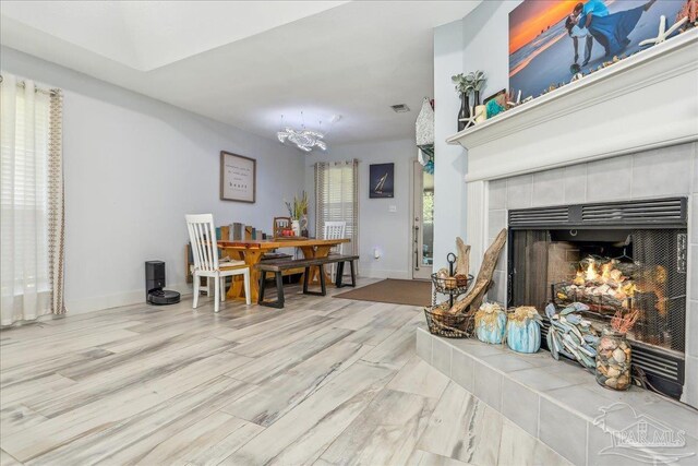 6961 Elliots Gin Ln, Navarre, FL 32566 - dining room with a chandelier, a tiled fireplace, baseboards, and wood finished floors