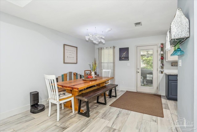 6961 Elliots Gin Ln, Navarre, FL 32566 - dining area featuring a chandelier, light wood-style flooring, and baseboards