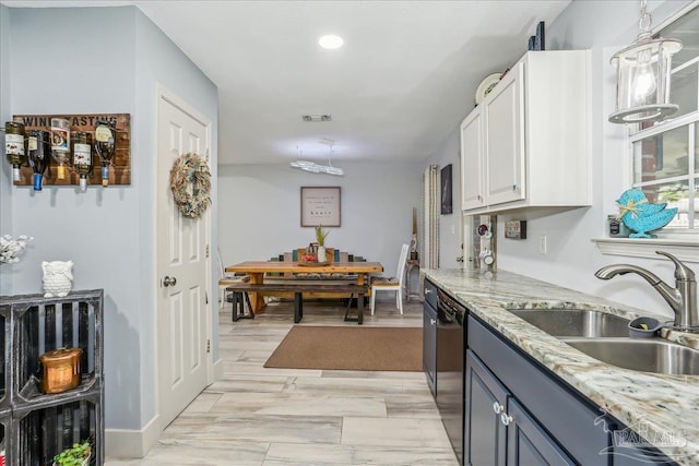 6961 Elliots Gin Ln, Navarre, FL 32566 - kitchen with a sink, black dishwasher, pendant lighting, white cabinetry, and light stone counters
