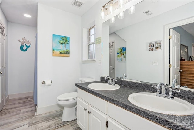 6961 Elliots Gin Ln, Navarre, FL 32566 - bathroom featuring toilet, double vanity, wood finished floors, and baseboards