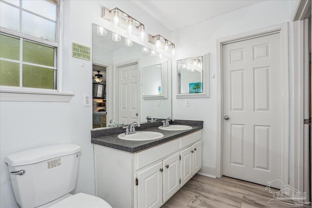 6961 Elliots Gin Ln, Navarre, FL 32566 - full bath with double vanity, toilet, wood finished floors, and ensuite bathroom