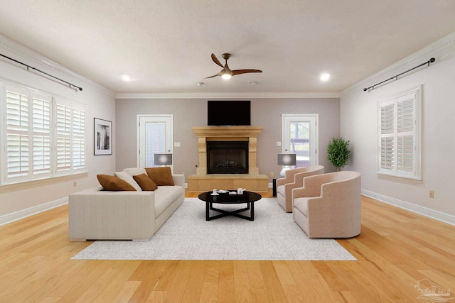 2960 Laurel Dr, Gulf Breeze, FL 32563 - living room featuring wood finished floors, ornamental molding, baseboards, ceiling fan, and a tile fireplace