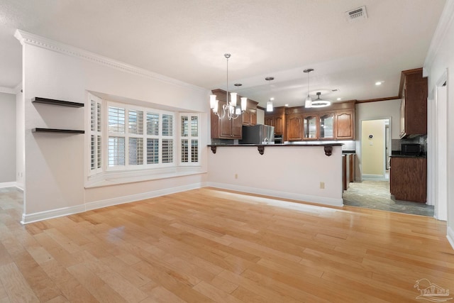 2960 Laurel Dr, Gulf Breeze, FL 32563 - kitchen featuring freestanding refrigerator, dark countertops, black microwave, a chandelier, and ornamental molding