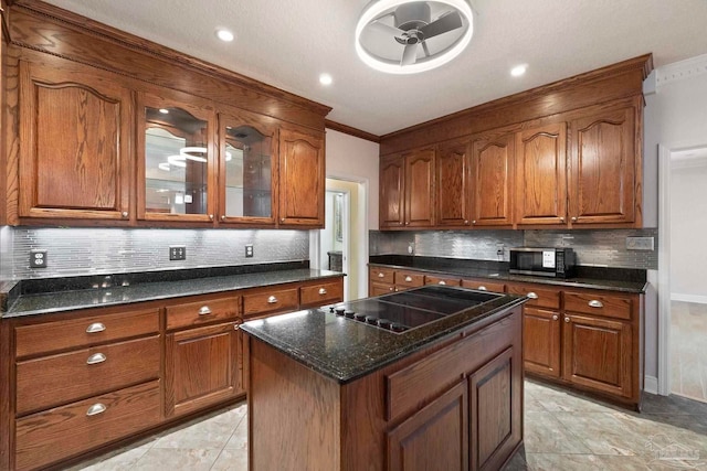 2960 Laurel Dr, Gulf Breeze, FL 32563 - kitchen featuring black electric stovetop, brown cabinets, backsplash, crown molding, and glass insert cabinets