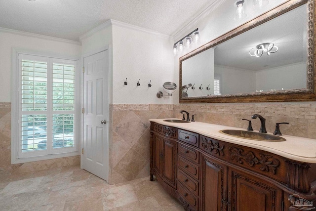 2960 Laurel Dr, Gulf Breeze, FL 32563 - bathroom with tile walls, a textured ceiling, ornamental molding, double vanity, and a wainscoted wall