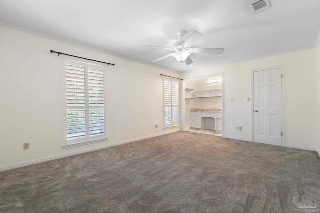 2960 Laurel Dr, Gulf Breeze, FL 32563 - unfurnished living room featuring healthy amount of natural light, a textured ceiling, ceiling fan, carpet flooring, and crown molding