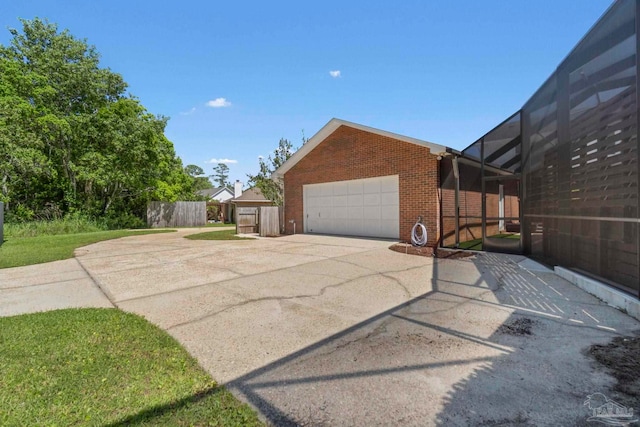 2960 Laurel Dr, Gulf Breeze, FL 32563 - view of side of property featuring brick siding, driveway, glass enclosure, fence, and an attached garage