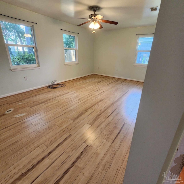 unfurnished room with ceiling fan, a wealth of natural light, and light hardwood / wood-style floors