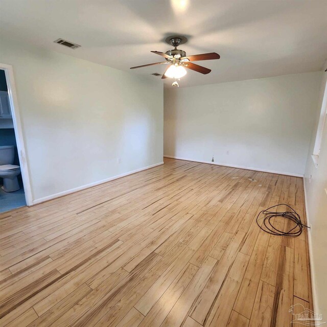 spare room with ceiling fan and light wood-type flooring