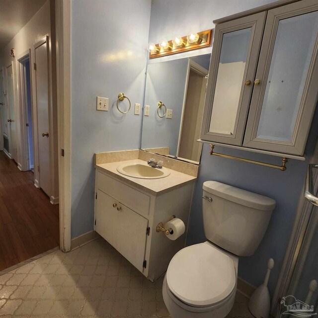 bathroom featuring vanity, toilet, and hardwood / wood-style floors