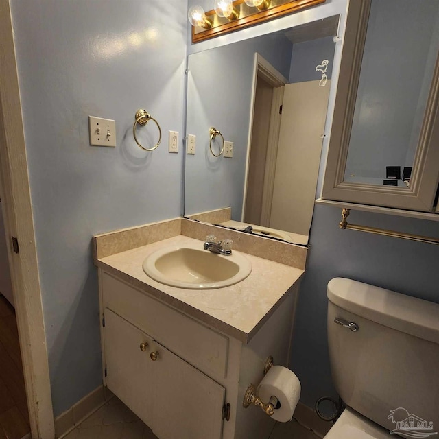 bathroom featuring tile patterned flooring, toilet, and vanity