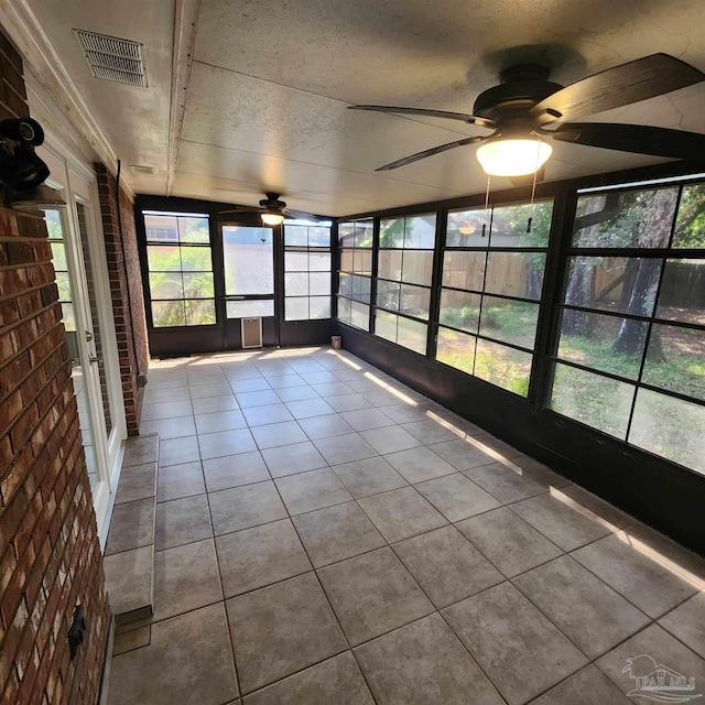 unfurnished sunroom featuring ceiling fan