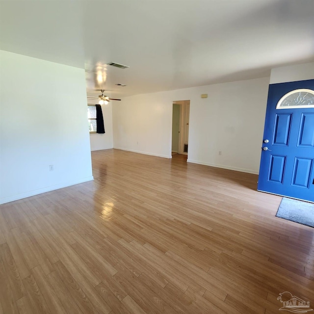 unfurnished living room featuring ceiling fan, a wealth of natural light, and wood-type flooring