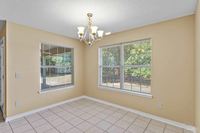 6299 Anderson Ln, Milton, FL 32570 - unfurnished room featuring a chandelier, plenty of natural light, a textured ceiling, and light tile patterned floors