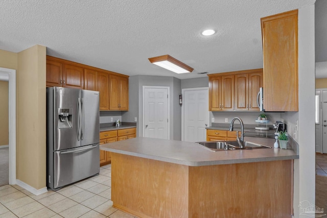 6299 Anderson Ln, Milton, FL 32570 - kitchen with appliances with stainless steel finishes, a peninsula, a textured ceiling, light tile patterned floors, and brown cabinets