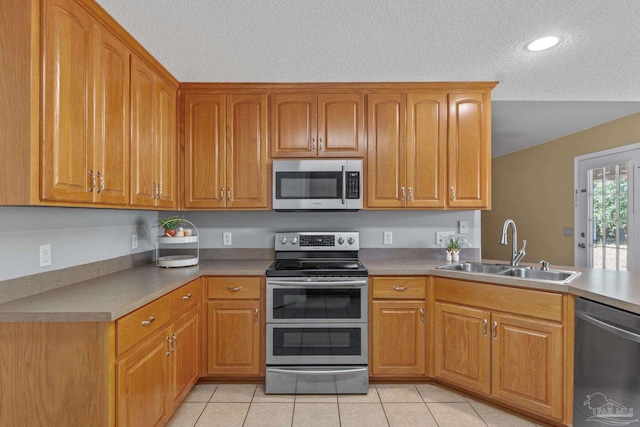6299 Anderson Ln, Milton, FL 32570 - kitchen featuring appliances with stainless steel finishes, a textured ceiling, brown cabinets, light tile patterned flooring, and recessed lighting