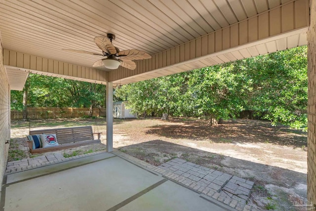 6299 Anderson Ln, Milton, FL 32570 - fenced backyard featuring ceiling fan, a patio area, and a storage unit