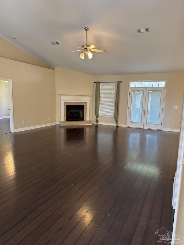 unfurnished living room featuring dark wood-type flooring, french doors, visible vents, and a fireplace with raised hearth