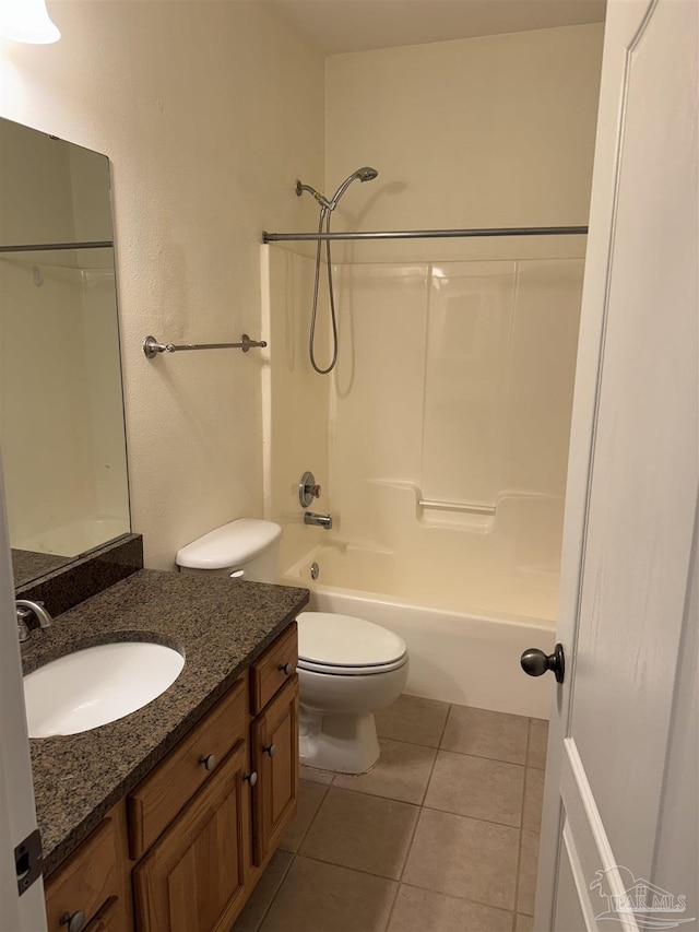 bathroom featuring tile patterned flooring, toilet, vanity, and bathing tub / shower combination