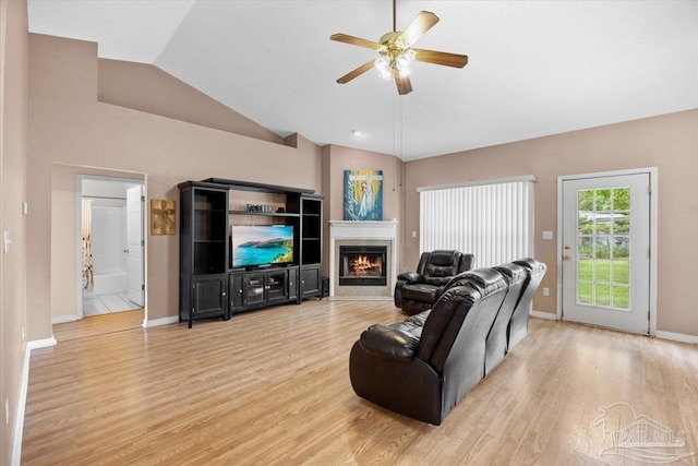 5761 Twisted Oak Ct, Pace, FL 32571 - living area featuring baseboards, a tiled fireplace, ceiling fan, vaulted ceiling, and light wood-type flooring